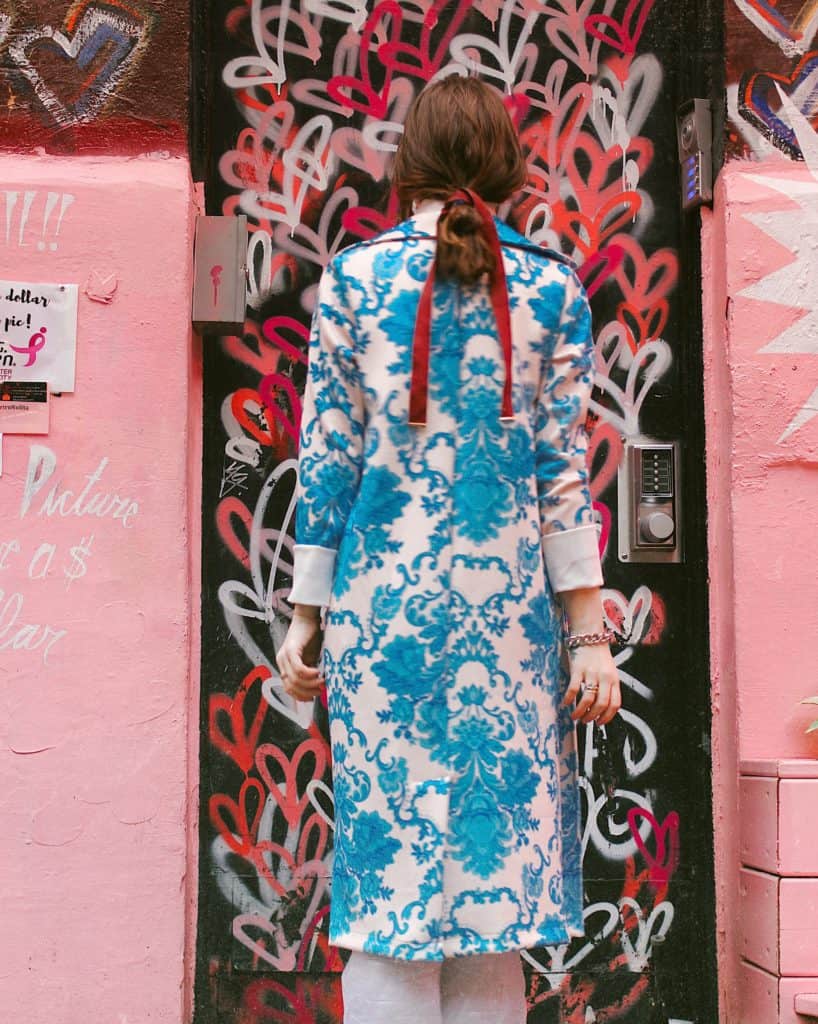 fashion blogger in floral coat with pink wall heart graffitt in background, dear influencer