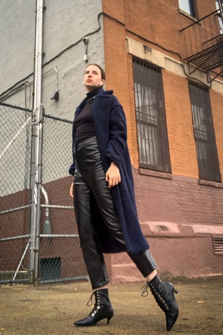 Gabrielle Arruda wearing monochrome winter outfit with black turtleneck, black leather pants, and navy/black teddy coat 
