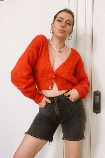 long denim shorts with spring fashion trend the oversized cardigan.  Style blogger gabrielle arruda wearing agolde denim shorts with red cardigan, pearl necklace, and double hoop earrings