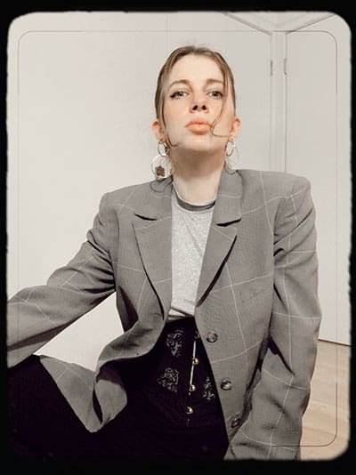 inspirație de stil pe gabrielle Arruda. până aproape de jumătate corset stratificat peste tee cu blazer și cerc declarație cercei