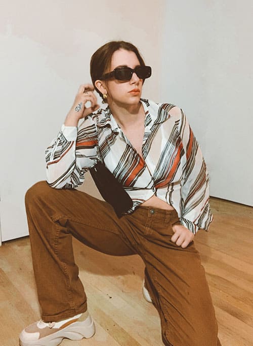 spring fashion trends 2021, psychedelic printed blouse on style blogger gabrielle arruda with straight leg brown pants and sneakers