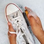 how to get shoes to be white again, hands scrubbing white converse in soapy water