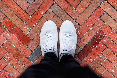 how to clean white sneakers with baking soda, image of clean white sneakers on brick floor