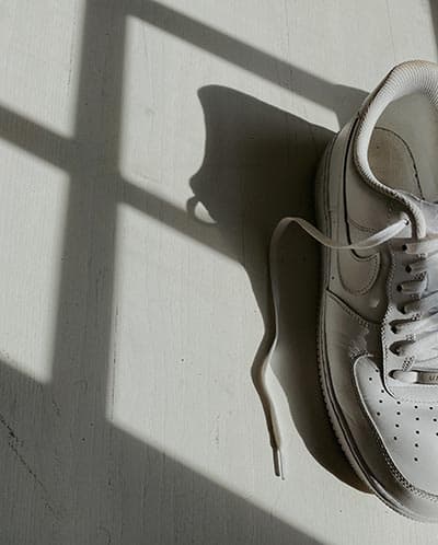 how to clean white sneakers, image of nikes with shoelaces draped on floor