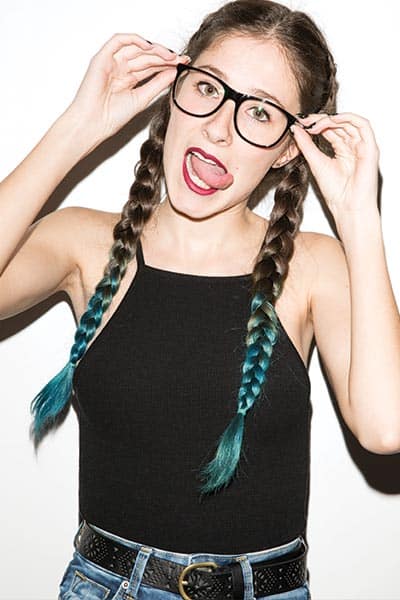 geeky chic, girl with braids with blue colored tip hair and thick black frame glasses