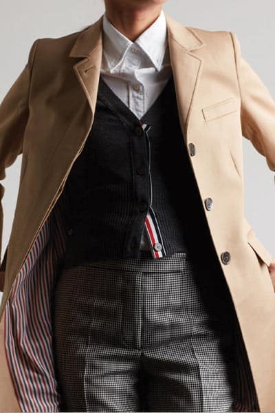 menswear fashion style, tomboy fashion style: image of woman wearing classic coat, vest, and shirt, trouser