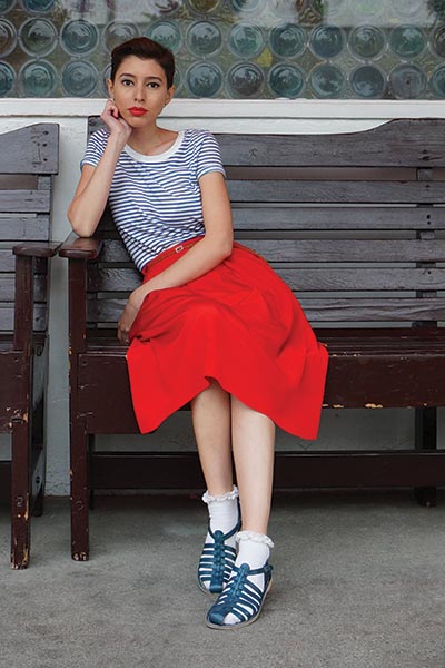 types of fashion styles, the retro style fashion. woman who embodies 1950's decade.  Retro hairstyle with red lipstick, striped tee and red a-line skirt.  