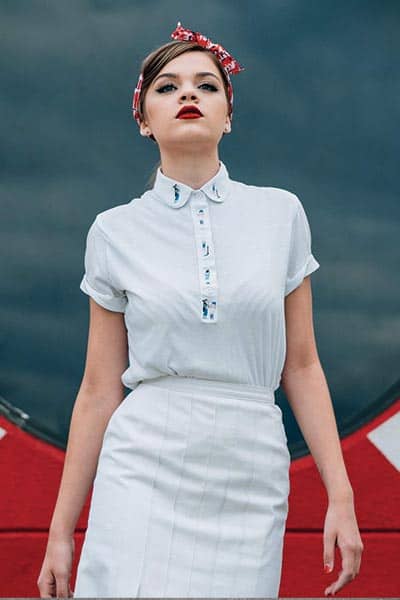 types of fashion styles, retro style. woman who embodies 1950's decade. Fitted blouse, hair scarf in hair with retro swoop bangs and a high waist skirt