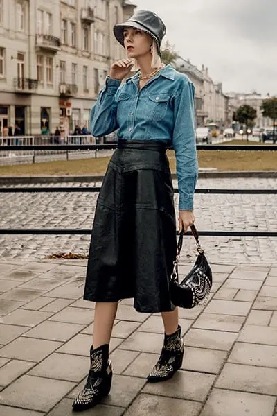 double denim outfit with denim shirt and denim skirt, accessories include bucket hat and boots. how to style double denim with two different denim washes 