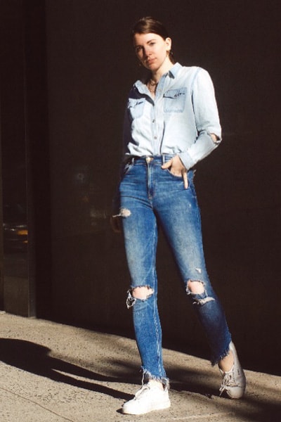 style blogger gabrielle arruda in an easy double denim outfit, light denim shirt with medium denim fitted jeans and sneakers 