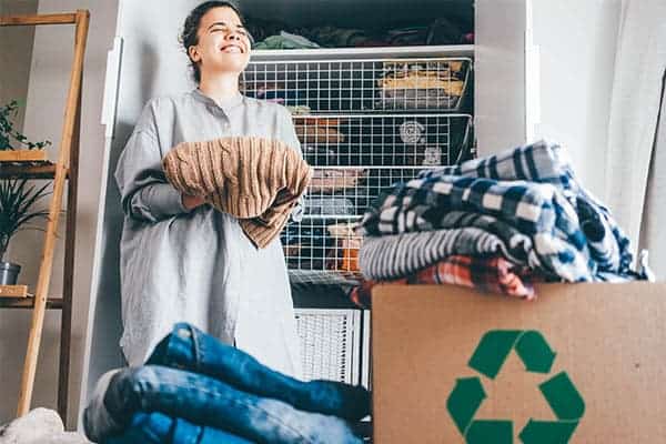 woman recycling clothes and cleaning out her closet following these rules for closet clean out 