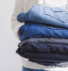 donna in possesso di una pila di jeans, migliorare stile da sapere che cosa avete nel vostro armadio