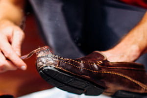 man taking tooth brush to a pair of used loafers, how to hand wash used shoes