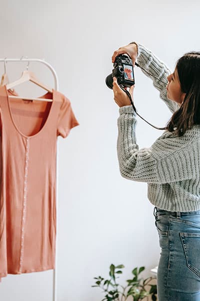 woman taking photos of clothing items for selling on poshmark