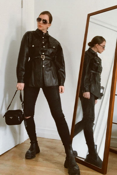 gabrielle arruda wearing an outfit inspired by rosie huntington whiteley. black utility top with belt, black skinny jeans, black chunky boots, prada handbag and aviator sunglasses