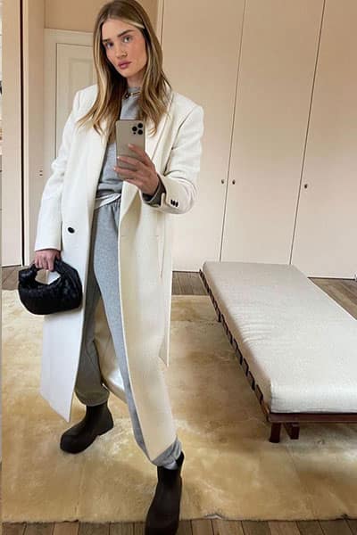rosie huntington whiteley style: gray sweatsuit with cream colored coat, bottega handbag and black chunky boots