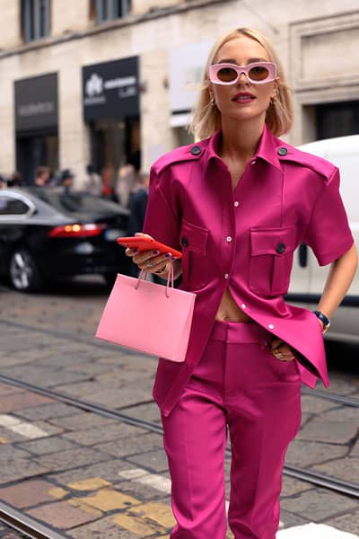 fashion week street style, influencer style icon wearing pink ensemble with utility detials and loewe pink sunglasses