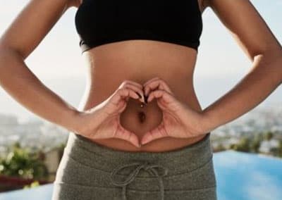 image of woman making a heart shape with hands over her stomach- love your body and you will look and feel prettier 
