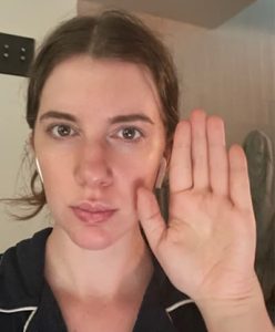 kibbe body test figuring out your hand size, example image of gabrielle arruda holding hand up to face for scale 