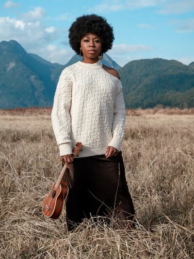 woman in field with chunky knit sweater that hits mid thigh with straight skirt, for flamboyant natural style lines