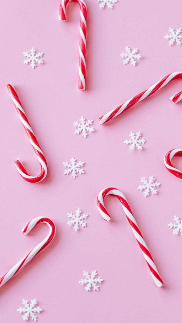 bubblegum pink background with snowflakes and candy canes, cute holiday wallpaper 