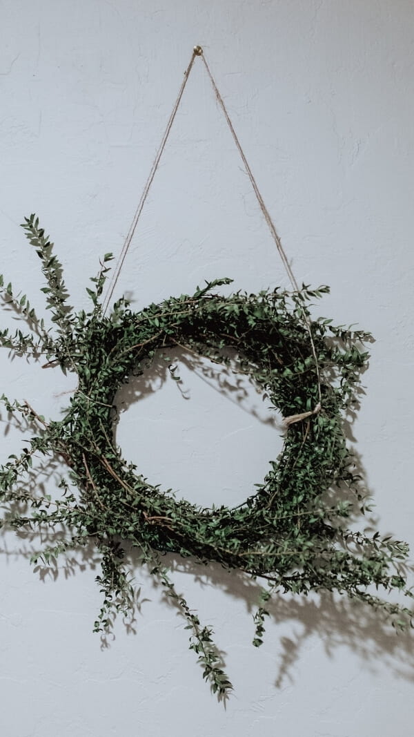 minimalist image of wreath (natural branches) on white background, iphone holiday wallpaper 