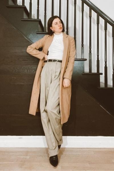 gabrielle arruda in winter capsule items: wool camel coat, white turtleneck, and wide-leg chino trouser in tan with black boots under
