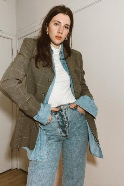 gabrielle arruda wearing a vintage fitted blazer with denim men's shit underneath and a white turtleneck under that with straight leg jeans for winter
