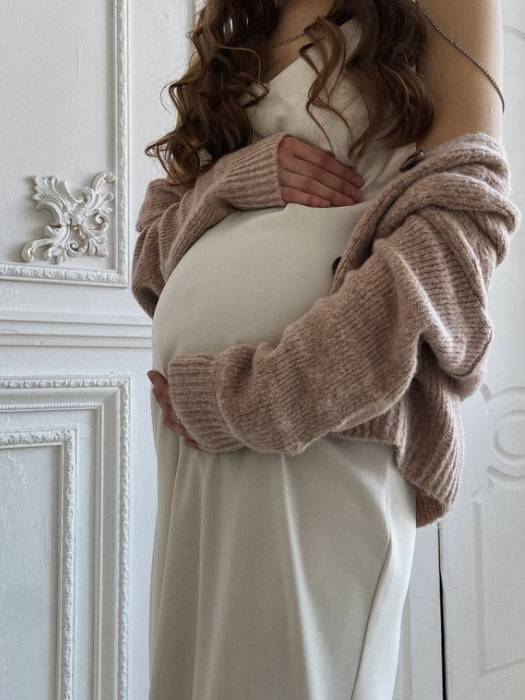 pregnant woman in slip dress holding bump