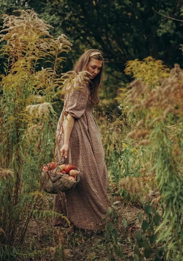 woman in field with apples in basket